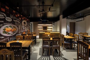 A restaurant with wooden tables and chairs, a chalkboard menu wall, and a modern interior design.