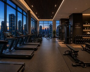 A gym with treadmills, weight machines, and a city view. - The Robertson by Bukit Bintang (Kuala Lumpur)