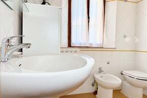 Ein Badezimmer mit Waschbecken, Bidet und Toilette.