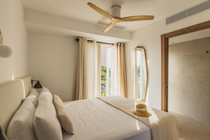 A bedroom with a bed, a ceiling fan, and a window with curtains. - Casa Olivera 2 bedroom apartment with 2 bathrooms, historic center of Dénia (Dénia)