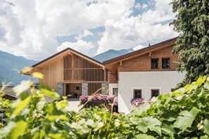 A wooden building with a sloped roof, large windows, and a stone entrance. - Chalet in the hay barn with private Finnish sauna (Raas)