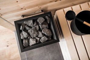 A black metal basket filled with rocks on a wooden surface. - Chalet in the hay barn with private Finnish sauna (Raas)