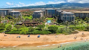 Ein Resort mit mehreren Gebäuden, einem Schwimmbad und einem Strand.