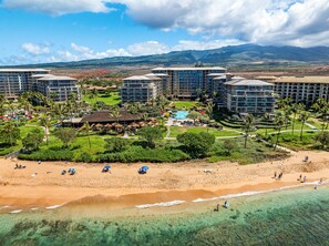 Ein Resort mit mehreren Gebäuden, einem Schwimmbad und einem Strand.