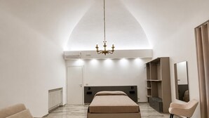 A modern bedroom with a bed, a chair, a wardrobe, and a chandelier. - Valentina Rooms – Elegant Stay in Bronte, Pistacchio e Etna. (Bronte)