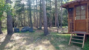 Een houten chalet met een veranda, omgeven door een bos.