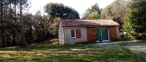 A small building with a tiled roof, a window, and a door.