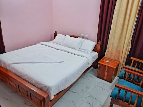 Una cama individual con estructura de madera, una mesita de noche y una silla con cojines azules.. LAKE OF ALSIMA