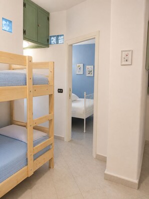 A room with bunk beds, a green cabinet, and a door leading to another room. - SMART EMERALD COAST (provincia della gallura nord-est sardegna)