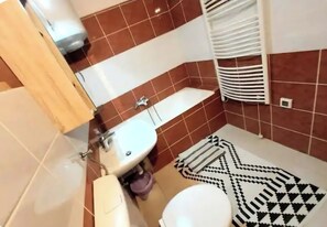 Ein Badezimmer mit Waschbecken, Toilette und Handtuchhalter.