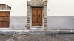 Un bâtiment doté d’une façade en pierre, d’une porte double en bois surmontée d’un arc en pierre et d’une enseigne portant le numéro « 18 ».