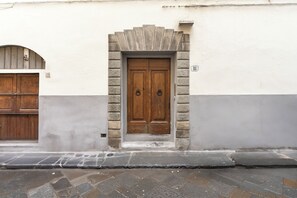 A building with a stone facade, a wooden double door with a stone archway, and a number '18' sign. - Elegant 2Bed apartment + 2Min from Ponte Vecchio (Firenze)