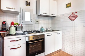A modern kitchen with white cabinets, a gas stove, an oven, and a sink. - Elegant 2Bed apartment + 2Min from Ponte Vecchio (Firenze)