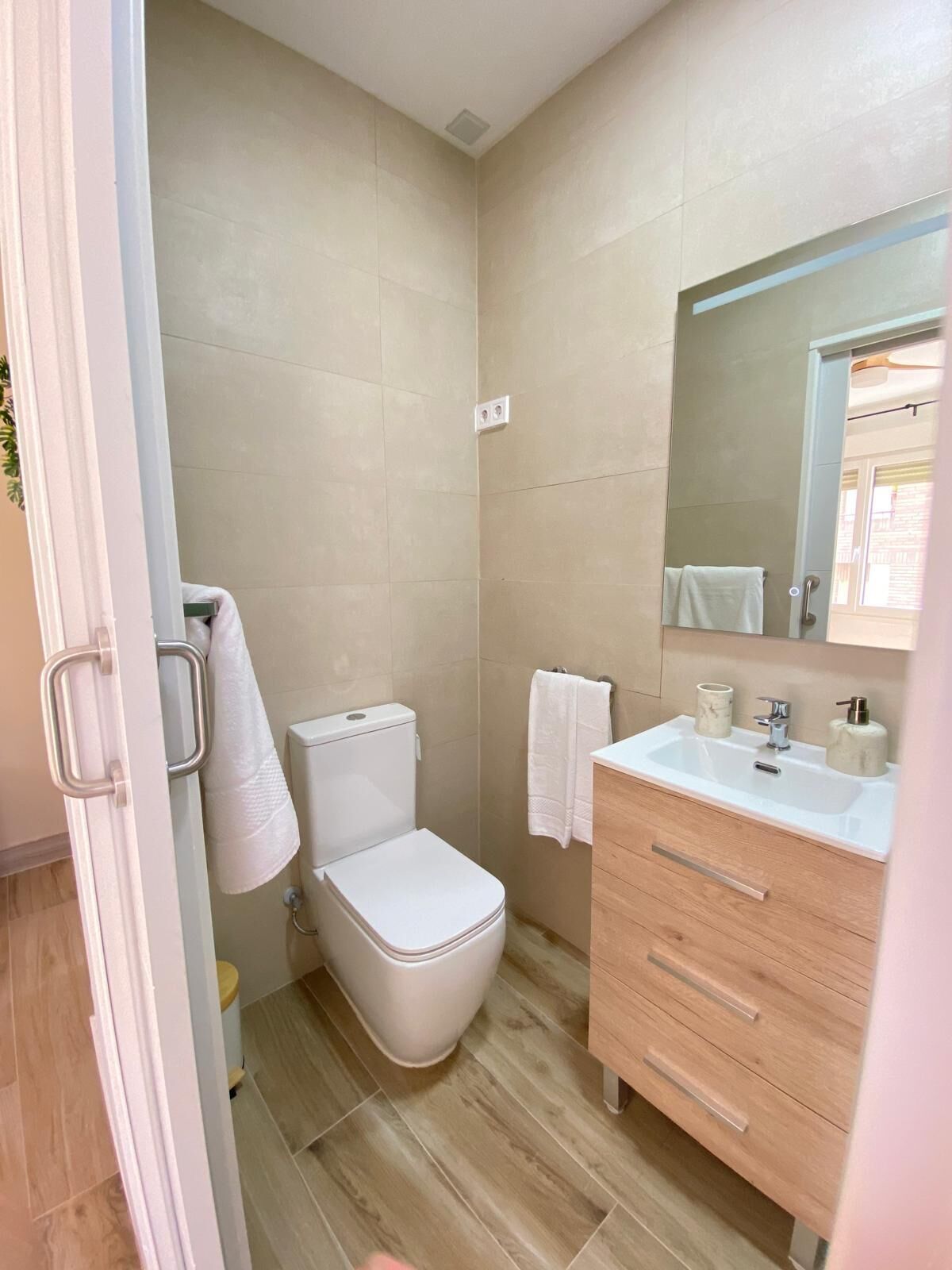 Un baño con inodoro, lavabo y espejo.
