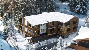 A modern wooden lodge with multiple balconies, surrounded by snow-covered trees. - La Villa Exclusive Suites - Alta Badia - NEW LUXURY APARTMENTS (Badia)