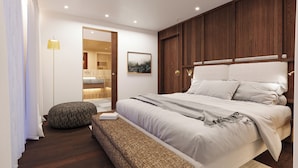 A bedroom with a large bed, a bedside table, a floor lamp, a wooden headboard, a painting, and a bathroom visible through an open door. - La Villa Exclusive Suites - Alta Badia - NEW LUXURY APARTMENTS (Badia)