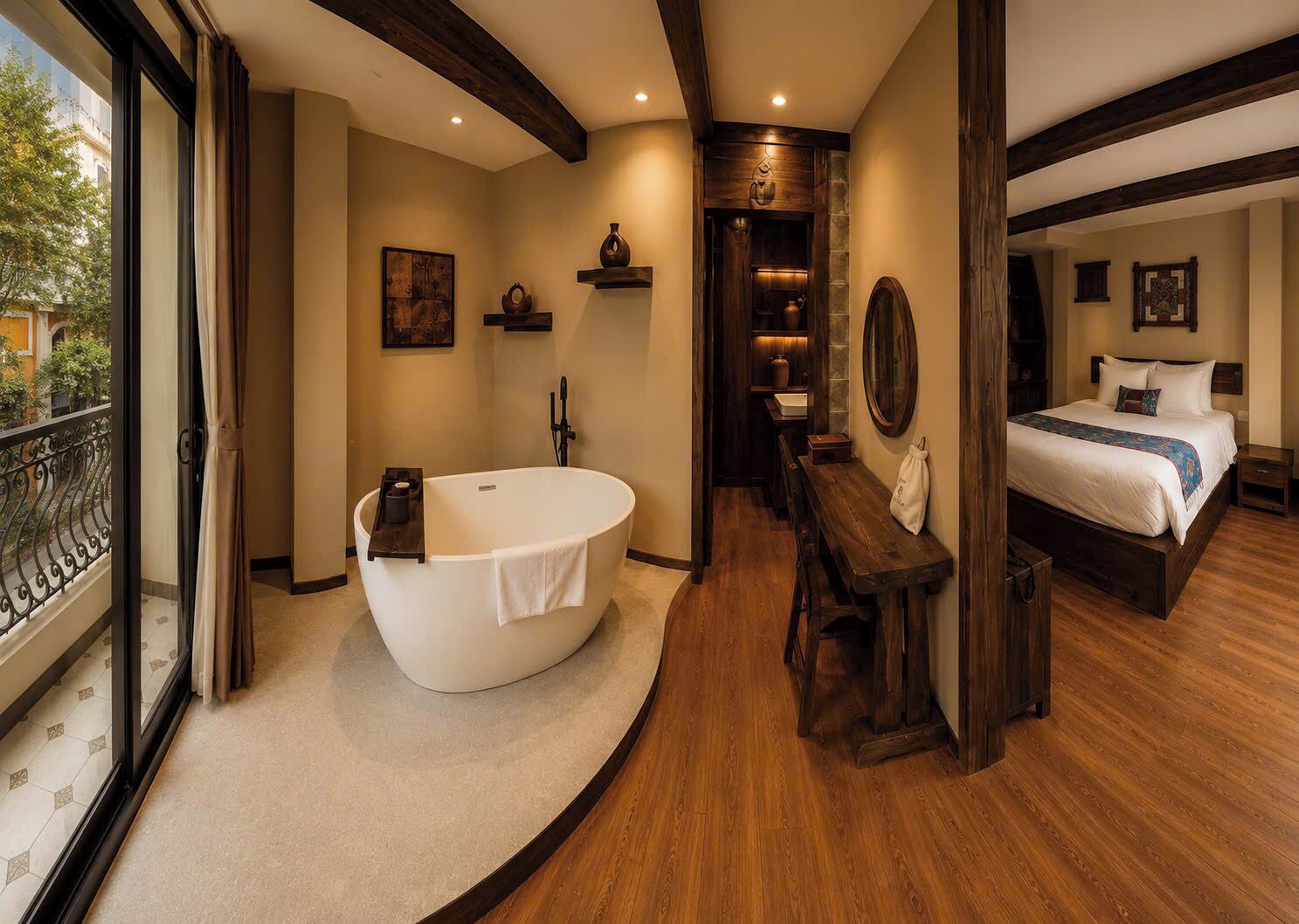 Un baño moderno con una bañera independiente, un banco de madera y un espejo grande.