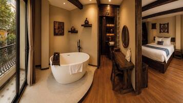 Un baño moderno con una bañera independiente, un banco de madera y un espejo grande.