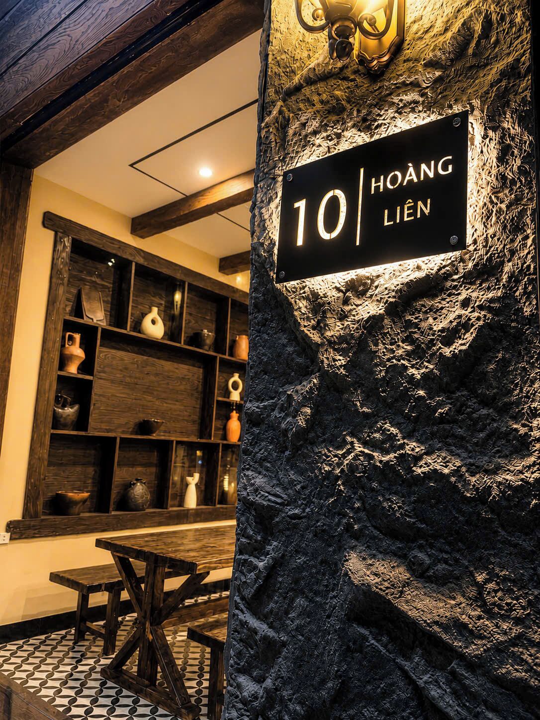 Un mur de pierre sur lequel est apposée une plaque indiquant le numéro de la chambre : 10, Hoàng Liên.