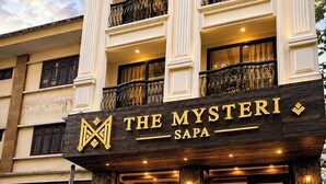 Entrada de un hotel con un letrero que dice 'The Mysterii Sapa'.