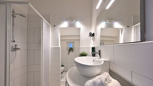 Een moderne badkamer met een inloopdouche, een groot wastafel en een spiegel.