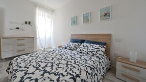 Een slaapkamer met een bed, nachtkastjes, een kaptafel en wanddecoratie.