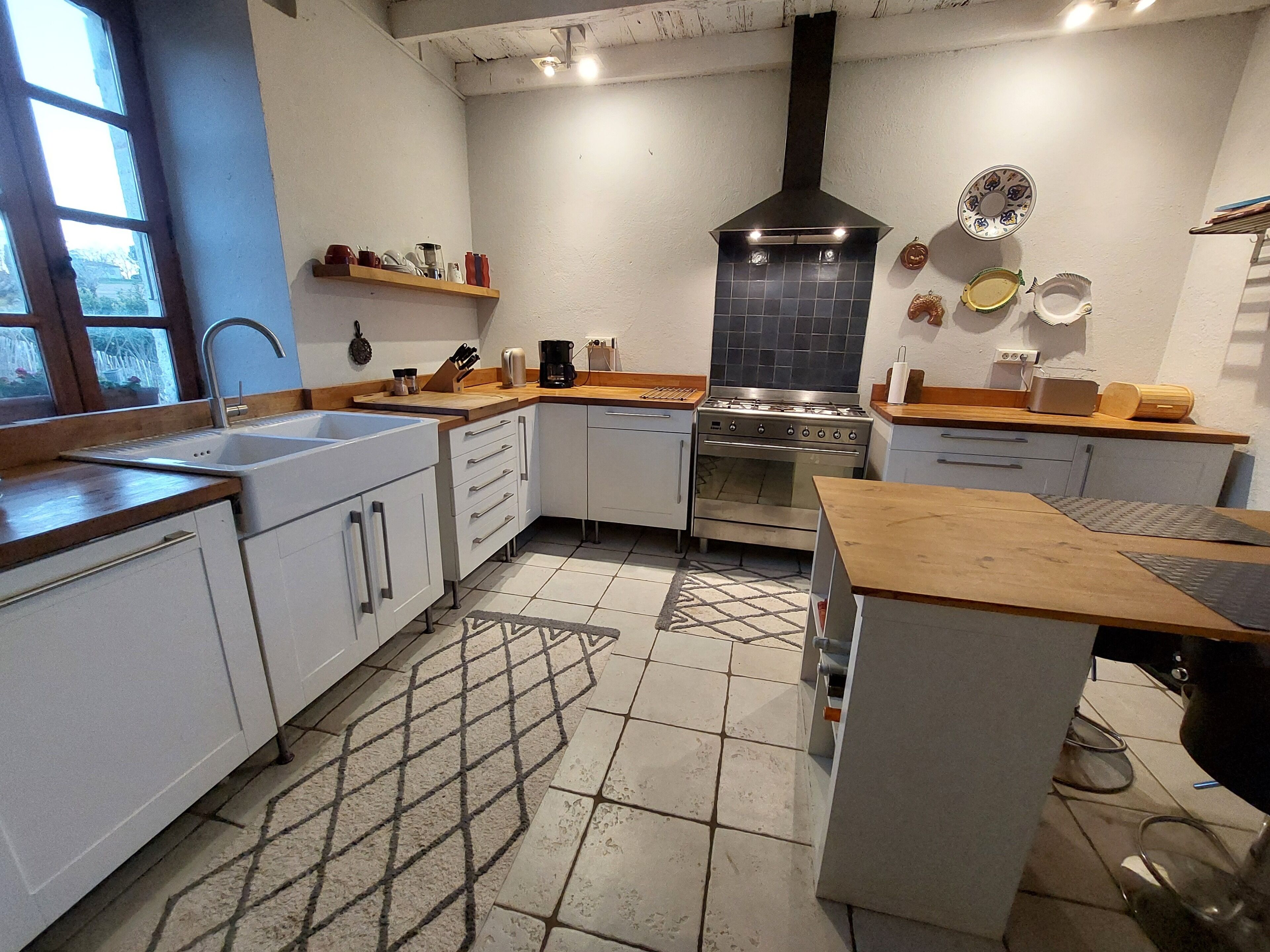 Una cocina con estufa, pileta y encimera de madera.