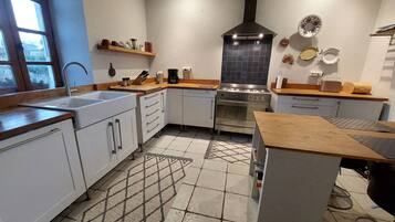 Una cocina con estufa, pileta y encimera de madera.