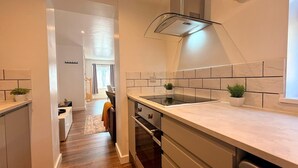 Uma cozinha moderna com uma ilha central, forno embutido e exaustor de aço inoxidável.