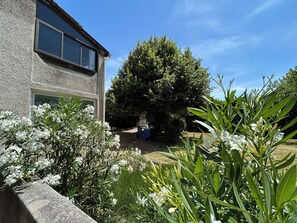 A residential building with a stone facade, a large tree in the backyard, and flowering plants. - Country House 2 apartments 15 kms from Vaison le Romaine facing Mont Ventoux, (Travaillan)