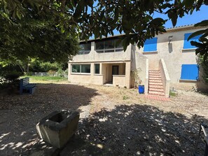 A building with a modern design, a concrete bench, and a blue barrel. - Country House 2 apartments 15 kms from Vaison le Romaine facing Mont Ventoux, (Travaillan)