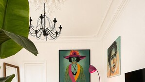 Ein Wohnzimmer mit einer Couch, einem Couchtisch, einem Fernseher und Kunstwerken an den Wänden.