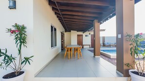 A covered patio area with a table and chairs, a pool, and potted plants. -  Villa Sweet, private pool & garden, 3 bedrooms, sleeps up to 8 guests (Oranjestad)