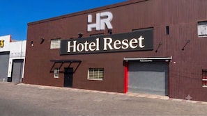 A building with a sign reading 'Hotel Reset' and a smaller sign for 'Restaurante El Pioa.'