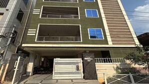 A multi-story residential building with a gated entrance, a covered driveway, and a balcony on the upper floor. - Aviora Residencies Gachibowli  (Hyderabad)