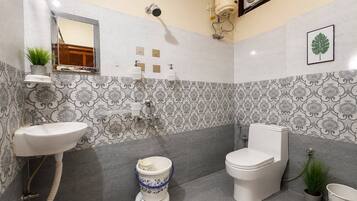 A bathroom with a sink, toilet, shower, and decorative tiles.