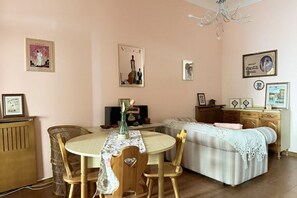 A cozy room with a bed, a dining table with chairs, a small TV, and framed pictures on the walls. - SE269 – Senigallia, one-bedroom apartment with air conditioning in the historic city center (Senigallia)