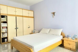 A bedroom with a bed, wooden wardrobe, bedside tables, and a wall-mounted decoration. - SE269 – Senigallia, one-bedroom apartment with air conditioning in the historic city center (Senigallia)