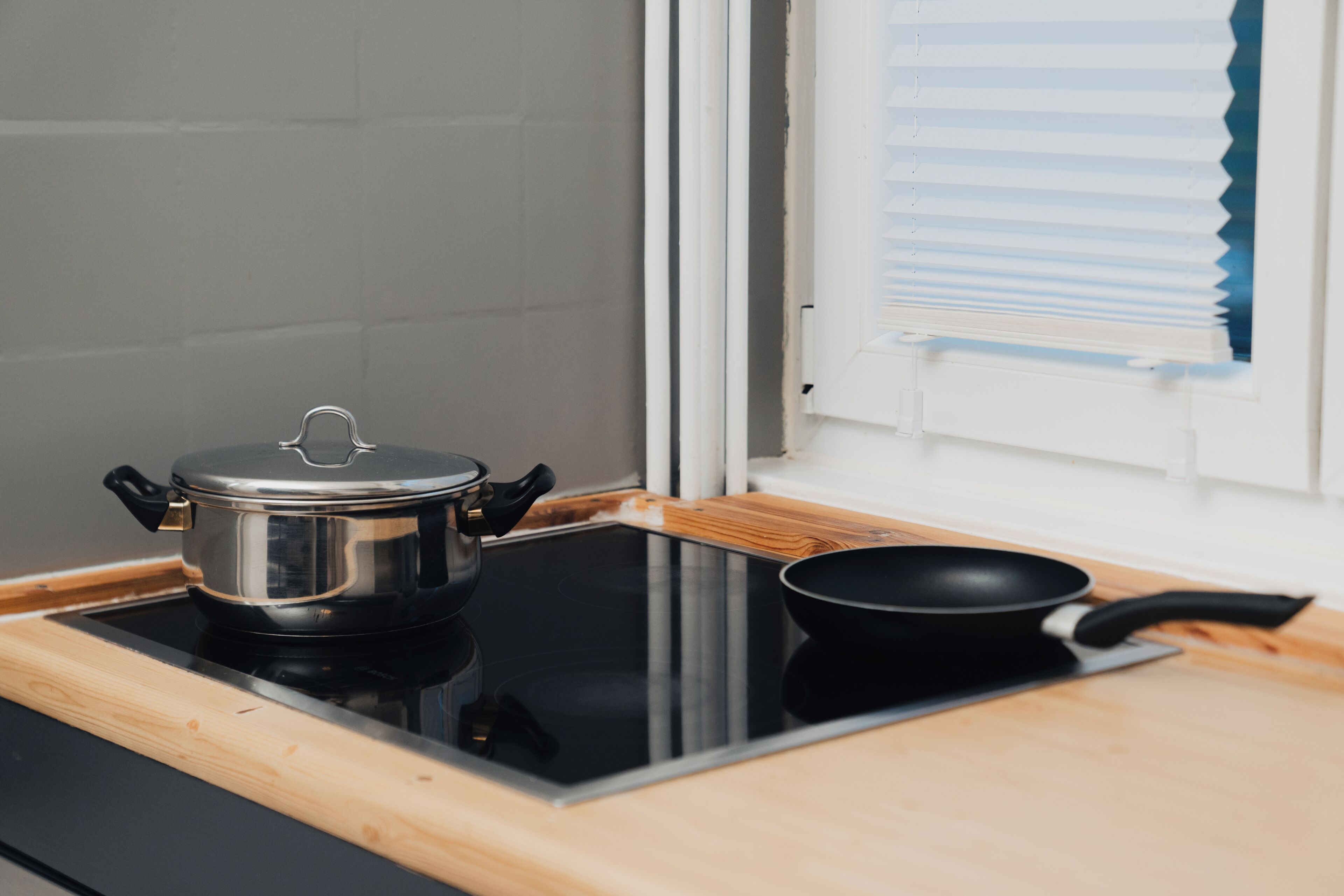 Une cuisine équipée d’une cuisinière, d’une casserole et d’une poêle.