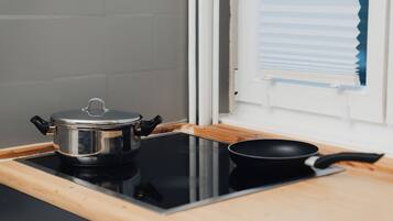 Une cuisine équipée d’une cuisinière, d’une casserole et d’une poêle.