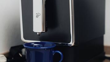A coffee machine with a blue cup holder and a silver logo.