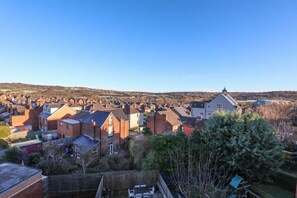 A residential area with houses, a large building with a tower, and a clear sky.