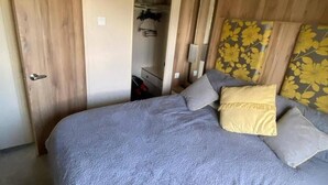 A bedroom with a bed, a wardrobe, and a door.