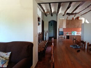 A living room with a wooden floor, a sofa, and a dining area with chairs and a table. - Country cottage. Totally isolated. Near Petrola salt lakes (Pétrola)