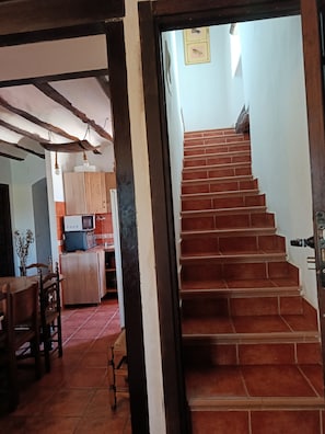A staircase leading to a landing with a kitchen area visible in the background.