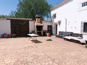 A courtyard with a tiled floor, a table, a bench, and a small garden area. - Country cottage. Totally isolated. Near Petrola salt lakes (Pétrola)