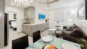 Une cuisine moderne avec un coin repas, un ventilateur de plafond et un téléviseur.