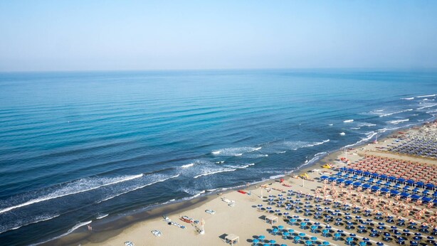 A beach with rows of umbrellas and sun loungers, a sandy shore, and the ocean. - Appartamento DUE Camere (Camaiore)
