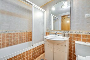 A bathroom with a bathtub, sink, toilet, and a mirror. - LXR Coloso, 2-bedroom apartment with an ocean view. (Benalmádena)