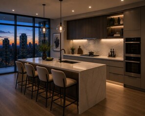Una cocina moderna con una isla grande, taburetes de bar, vistas a la ciudad y electrodomésticos integrados.